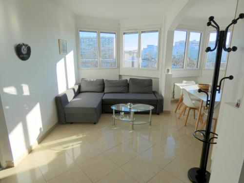 un salon avec un canapé et une table dans l'établissement 37m2 lumineux face gare SNCF, WIFI et café et thé offerts, à Orléans