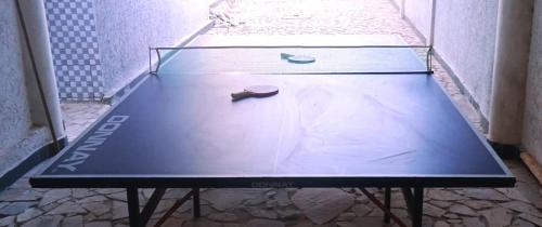 a ping pong table with a tennis racket on it at La Résidence in Lomé
