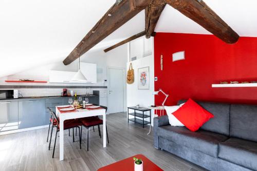 a living room and kitchen with a red wall at Villa Bice in Bergeggi