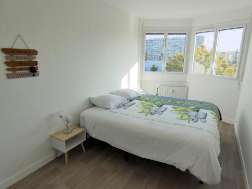 a white bedroom with a bed and two windows at 37m² lumineux face gare SNCF + café et thé offerts in Orléans