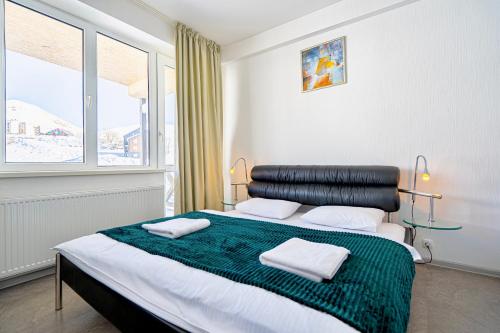 a bedroom with a bed with two towels on it at 2-room Apartment Gudauri Penta 703 in Gudauri