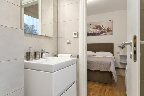 bagno bianco con lavandino e letto di Villa Aurea a Linardići