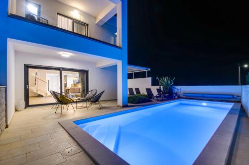 a swimming pool in the backyard of a house at night at Villa Aurea in Linardići