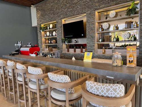 bar z rzędem stołków w restauracji w obiekcie Espectacular Apartamento Frente al Mar exclusivo Resort w mieście Puerto de Gaira