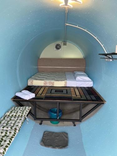 キャメロンハイランドにあるCameron Highlands Blueberry Earth Houseのベッドとテーブル付きの小さな部屋