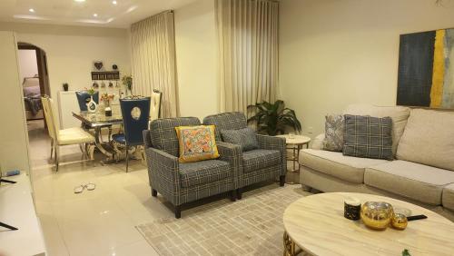 a living room with a couch and chairs and a table at شقة متكاملة VIP غرفتين وجلسة خارجية in Riyadh