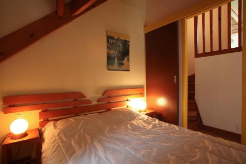 a bedroom with a bed with two lights on it at VVF Fouesnant les Glénan in Fouesnant