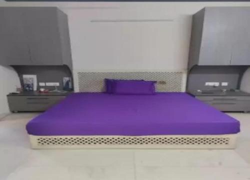 a bedroom with a purple bed with two dressers at Vacoas Vacacciones in Réunion