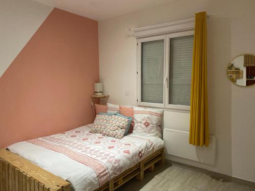 ein kleines Schlafzimmer mit einem Bett und einem Fenster in der Unterkunft La petite Escapade in Calais