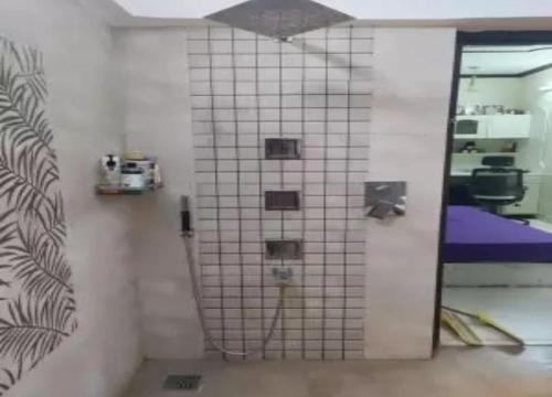 a bathroom with a tiled wall with a mirror at Vacoas Vacacciones in Réunion