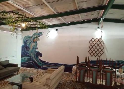 a living room with a painting on the wall at Casa de playa de boca de río Primera fila - Playa planchon in Tacna