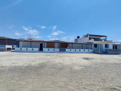 un grupo de edificios en un campo situado junto a un edificio en Casa de playa de boca de río Primera fila - Playa planchon, en Tacna