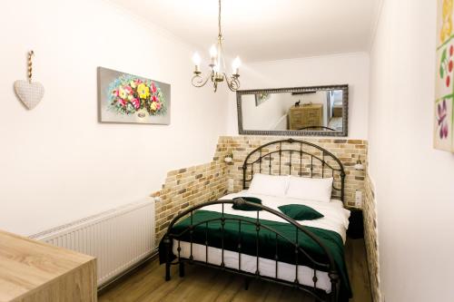 a bedroom with a bed with a mirror on the wall at Gong Apartments in Sibiu