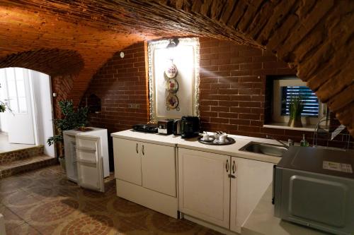 a kitchen with a sink and a brick wall at Gong Apartments in Sibiu