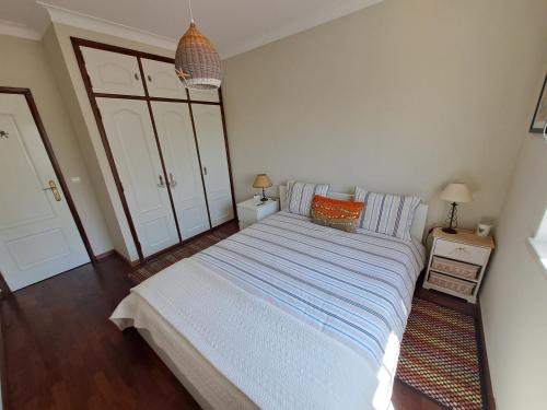een slaapkamer met een groot bed met blauwe en witte lakens bij Peniche House in Atouguia da Baleia