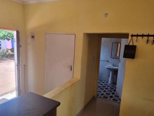 um corredor com uma porta e um lavatório num quarto em Town Centre Apartment em Livingstone