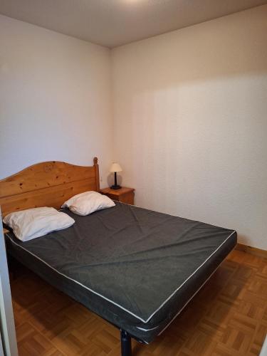 une chambre avec un grand lit avec deux oreillers dans l'établissement Appartement dans un chalet, résidence avec piscine, à La Toussuire