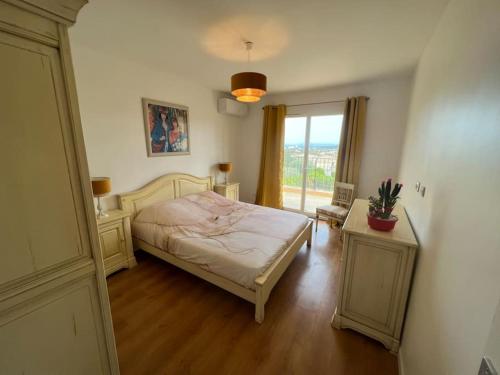 une chambre avec un lit et une grande fenêtre dans l'établissement jolie villa avec vue mer, à Bormes-les-Mimosas