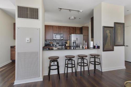 a kitchen with three bar stools at a counter at Penthouses near Fulton Market-Cloud9-365 in Chicago