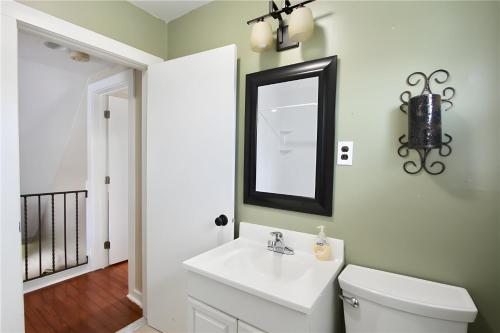 W łazience znajduje się biała umywalka i lustro. w obiekcie Apartment 4bdr 2-3 floor, waterview, walk to beach w mieście Middletown