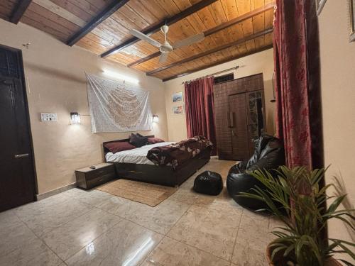 a bedroom with a bed and a couch in a room at Karvaan B&B - 2bhk Homestay in Pālampur