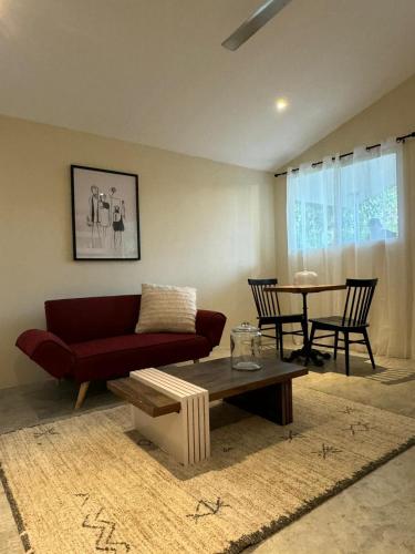 ein Wohnzimmer mit einem roten Sofa und einem Tisch in der Unterkunft Finkita Nosara House R in Nosara
