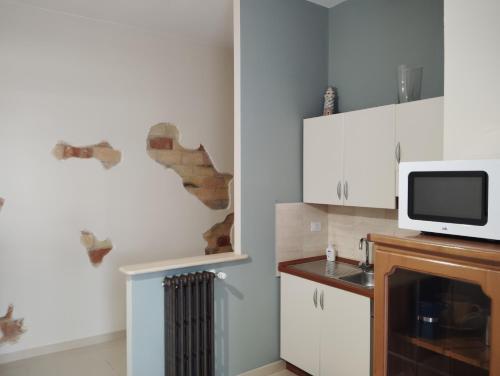 a kitchen with white cabinets and a microwave at Short Lets Pescara in Pescara
