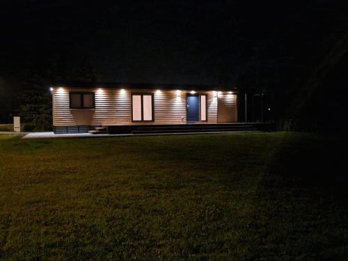 a small house with lights on the side of a field at Apartmán Andrea in Červená Voda
