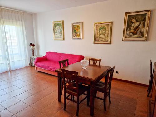 uma sala de estar com uma mesa e um sofá vermelho em DOMUS DIVI - Eur Torrino em Roma