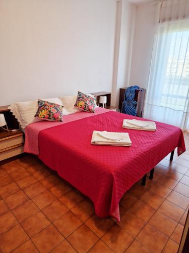 a bedroom with a red bed with two napkins on it at DOMUS DIVI - Eur Torrino in Rome