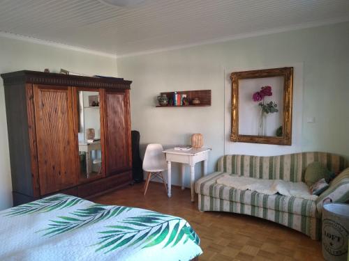1 dormitorio con cama, sofá y mesa en Ferienhaus -Wesertal en Gottstreu