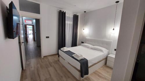 a white bedroom with a bed and a hallway at Lemon Tree Home in Castellón de la Plana