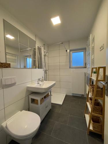a bathroom with a white toilet and a sink at Die lütte Welle Grömitz in Grömitz