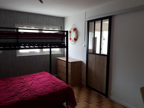 a bedroom with a bunk bed with a red bedspread at Mer campagne vignobles in Brétignolles-sur-Mer