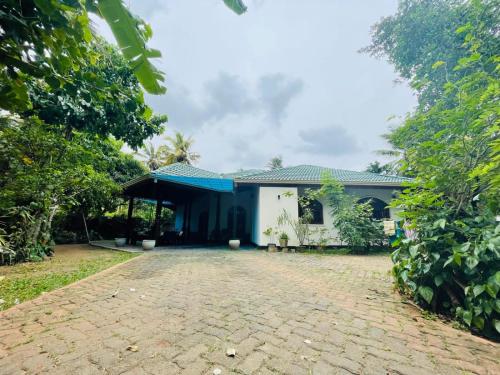 a house with a cobblestone driveway in front of it at Langama Thena - ළඟම තැන in Anuradhapura
