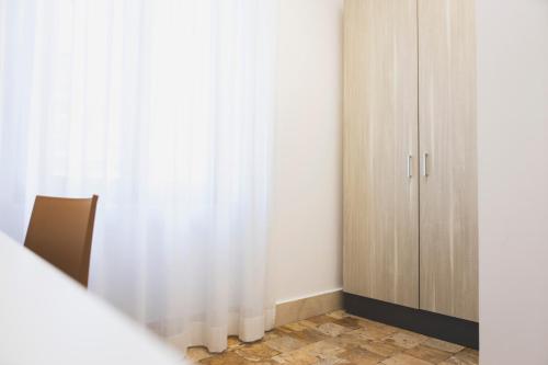a bedroom with a white curtain and a cabinet at B&B Palazzo Storico Di Nicola in Pescara
