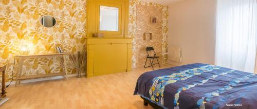 een slaapkamer met een bed en een gele muur bij RÉF 483 - LORIENT maison de ville avec terrasse jardinet in Lorient