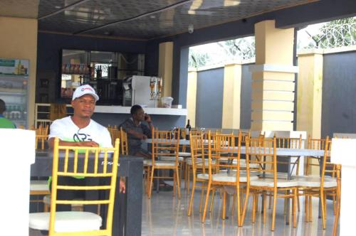 un hombre sentado en una mesa en un restaurante en STARSAPPHIRE LUXURY HOTELS LTD, 