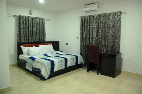 a bedroom with a bed and a desk and curtains at STARSAPPHIRE LUXURY HOTELS LTD 