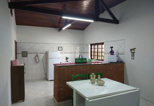 uma cozinha com um balcão branco e um frigorífico em Chácara em Indaiatuba em Indaiatuba
