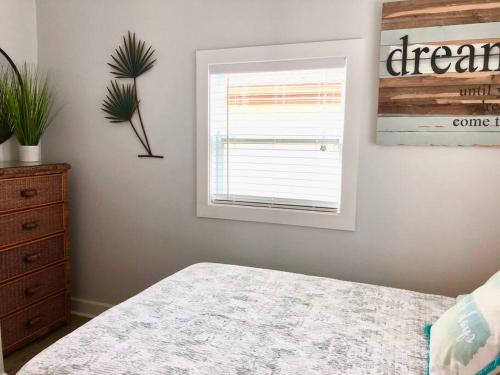 a bedroom with a bed and a window and a dresser at In the Heart of Downtown Dunedin One Bedroom Apt NO KIDS, NO PETS in Dunedin