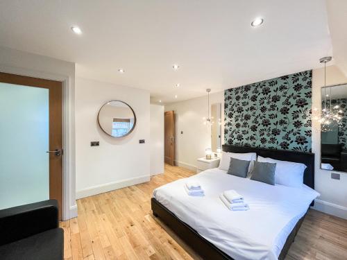 um quarto com uma grande cama branca e um espelho em Large and very stylish apartment em Londres