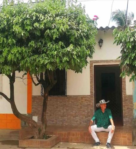 a man sitting on a bench next to a tree at Apartamento Concepción Mompox in Mompós