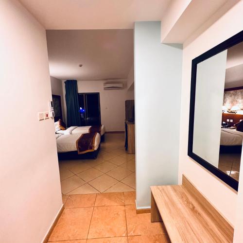 a hallway with a room with two beds and a mirror at Aquavista Hotel & Suites in Aqaba
