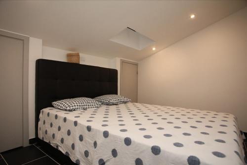 a bedroom with a bed with a black headboard and two pillows at Geneve Old Town Apartment in Albufeira
