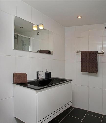 a white bathroom with a sink and a mirror at Geneve Old Town Apartment in Albufeira
