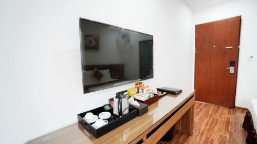 a living room with a table with a tv on the wall at Lam Anh Hotel Dương Nội Hà Đông in Hanoi