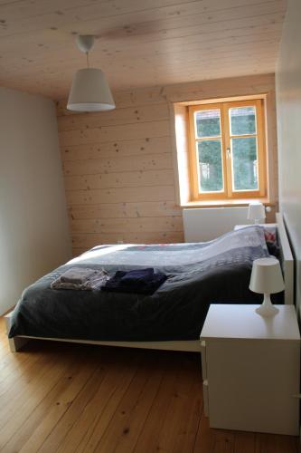 ein Schlafzimmer mit einem Bett in einem Holzzimmer in der Unterkunft Gite le petit Québec 