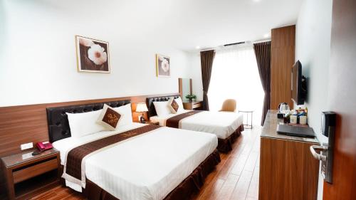 Lam Anh Hotel Dương Nội Hà Đông في هانوي: غرفة فندقية بسريرين وتلفزيون بشاشة مسطحة