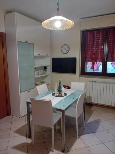 comedor con mesa y sillas blancas en Casa rosa en Arezzo
